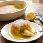 Delia Smith lemon surprise pudding served with lemon sauce and icing sugar