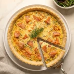 Baked smoked salmon and dill quiche with a slice cut showing salmon and dill filling