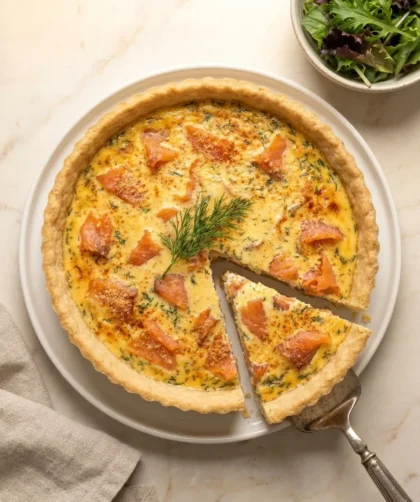 Baked smoked salmon and dill quiche with a slice cut showing salmon and dill filling